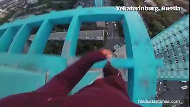 Stomach-churning footage shows Russian daredevil hanging from a 40-storey building without safety gear