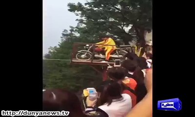 Man rides bike on rope.