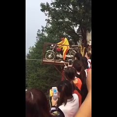 Conduire une moto sur un fil tendu au-dessus de la haute altitude