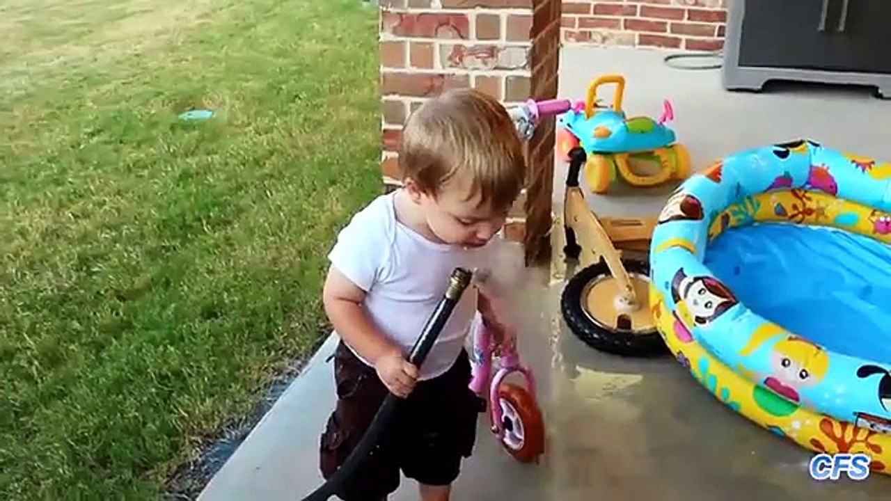 Crianças tentar beber água de uma mangueira. crianças engraçadas