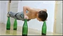 Small Boy Doing Push Ups on beer bottles