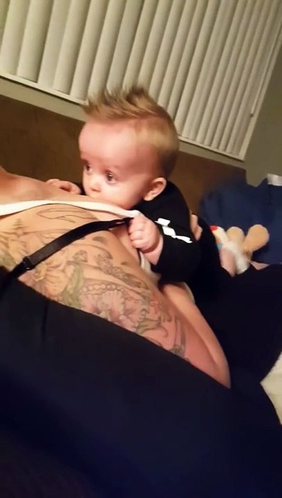 Un bébé joue avec les seins de sa maman