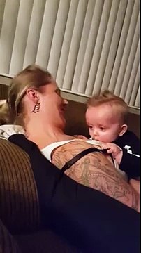 Un bébé joue avec les seins de sa maman