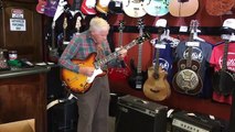 81-летний дедушка проверяет гитару перед покупкой