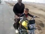 A 2 year old baby riding a bike in Pakistan - Very Dangerous