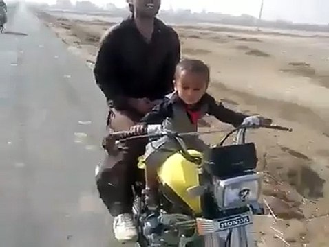 A 2 year old baby riding a bike in Pakistan - Very Dangerous