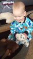 Baby laughs because of Puppy playing around him