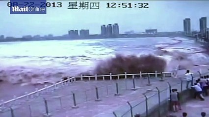 Tidal bore sweeps visitors along China river