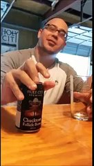 Bald guy pours a beer using his forehead