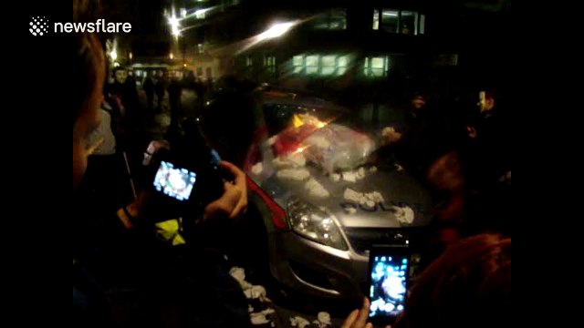 Protesters set fire to police car in London