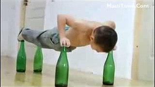 Small Boy Doing Push Ups on beer bottles