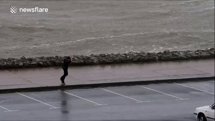 Boy struggles to walk against wind in Ireland