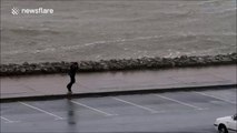 Boy struggles to walk against wind in Ireland