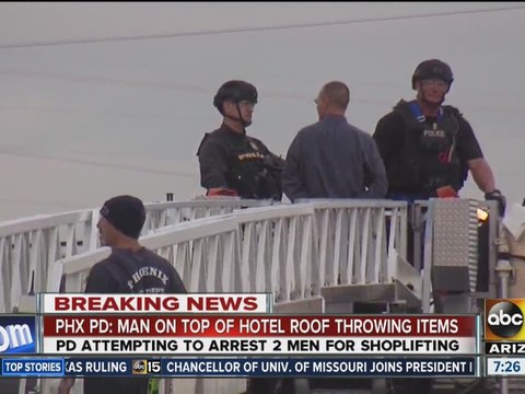Man on top of motel roof throws items at police