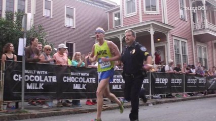 Police officer helps bloodied runner cross finish line