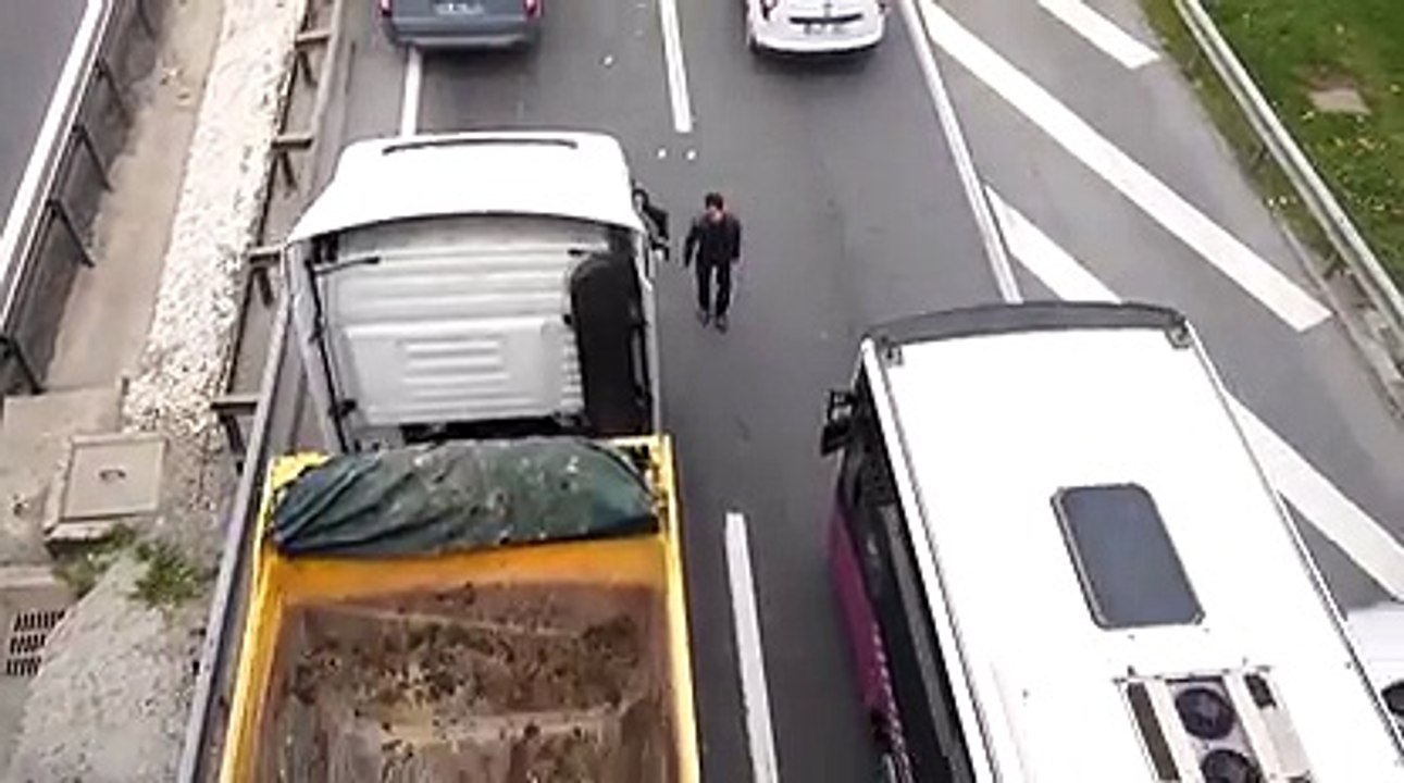 Au milieu de la route, il colle des autocollants. Tranquille!