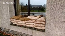 People deploy sandbags to protect against flooding in Cumbria, UK