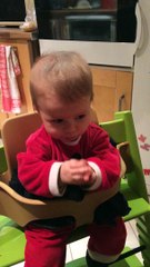 Agathe rigole sur sa chaise haute