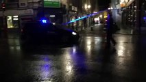 Une voiture de police semble partir sur le terrain dimanche soir à Bruxelles dans le cadre d'opérations liées aux attentats de Paris