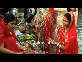 Indian women stand in cold water and pray at Chhat festival