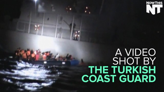 Passenger On A Greek Ship Tries To Deflate A Rubber Boat Carrying Refugees