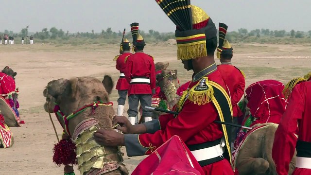 Dudelsack-Kameltruppe reitet durch Wüste in Pakistan
