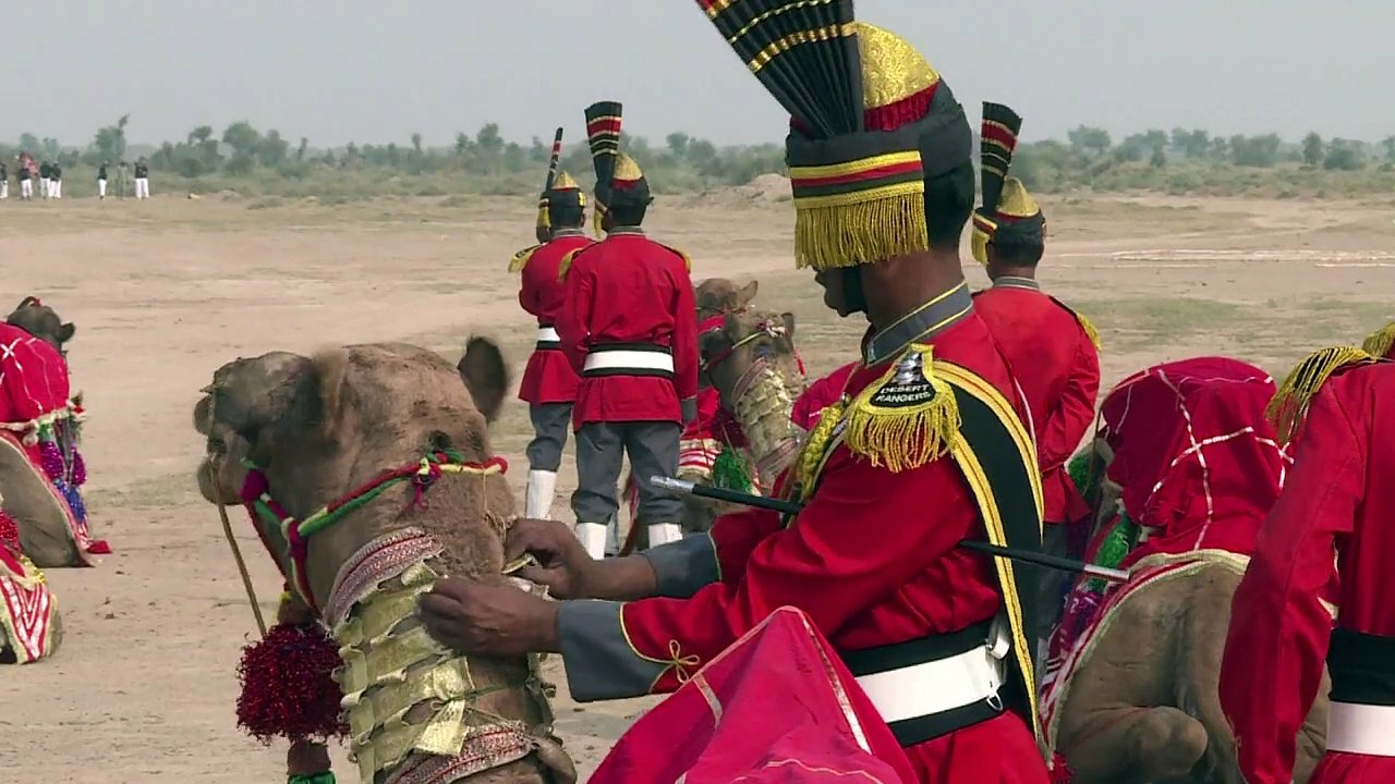 Dudelsack-Kameltruppe reitet durch Wüste in Pakistan