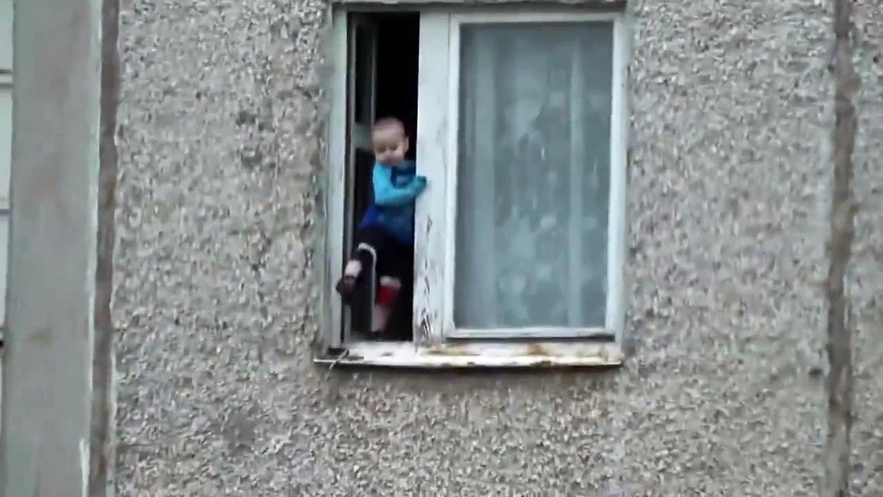Worst parents ever Russian toddler hangs out of 8th floor wi