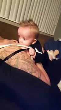 Un bébé joue avec les seins de sa maman