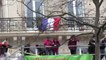 Un manifestant arrache un drapeau français sous les applaudissements de la foule place de la République