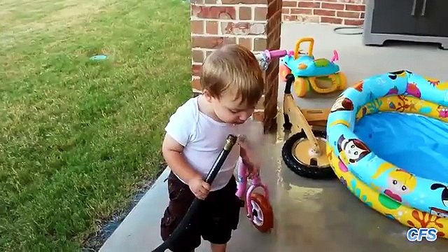 Crianças tentar beber água de uma mangueira. crianças engraçadas