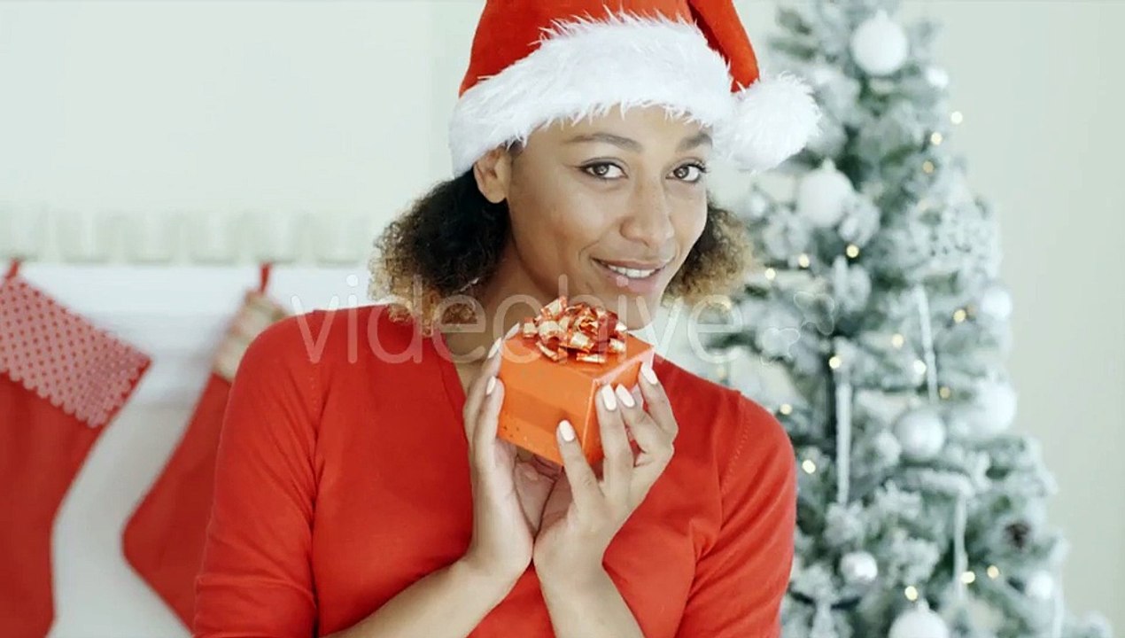 Pretty Woman In Santa Hat Holding a Gift | Stock Footage - Videohive