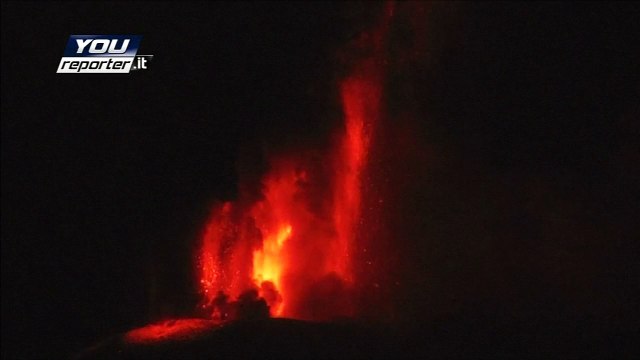 Erupting volcano lights up the night sky with red-hot lava
