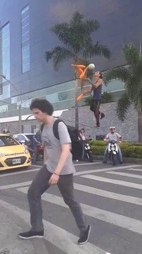 Guy does tight rope juggling tricks on street while traffic lights are red