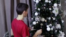 Little Boy Hangs White Toy On Decorated Xmas Tree | Stock Footage - Videohive