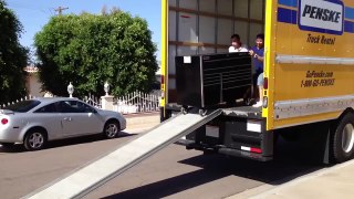 Deux abrutis déchargent une boîte à outils de leur camion