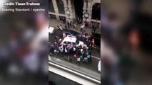 Incredible moment crowd lifts taxi to rescue trapped woman