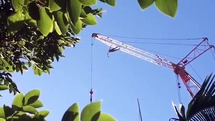 Gros fou qui escalade une grue !