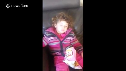 Lazy toddler shows its alright to lie on the couch and eat crisps
