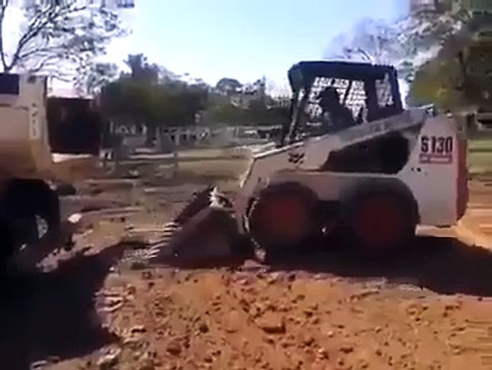 Professional driver loads compact track loader into truck