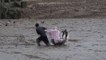 Un Thaïlandais aide deux touristes bloqués dans la boue