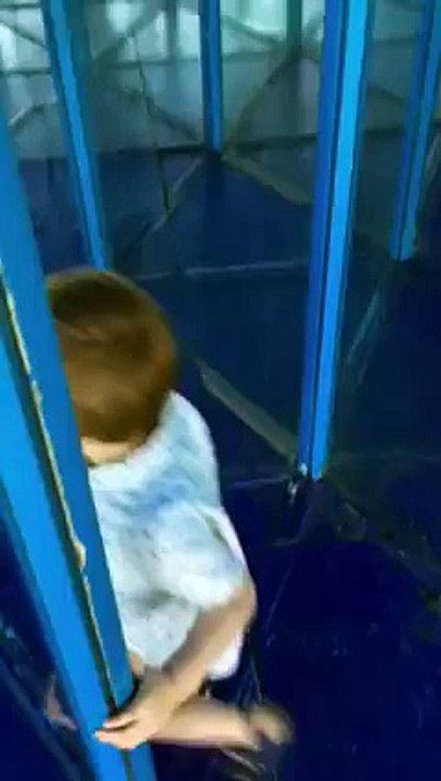 Un enfant passe devant dans un labyrinthe de miroirs