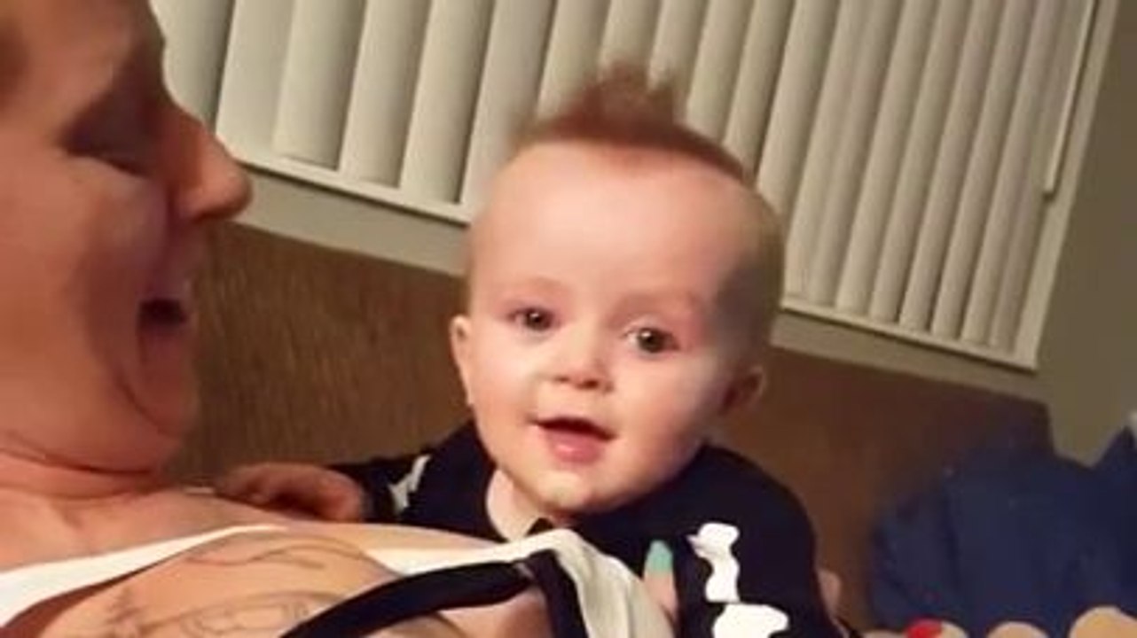 Un bébé joue avec les seins de sa maman