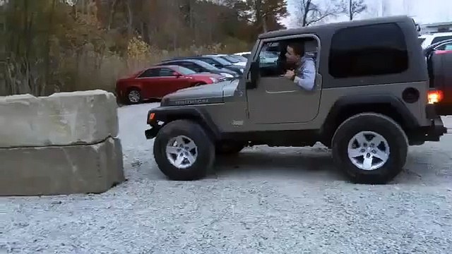 Une Jeep tente de grimper sur un bloc de béton...