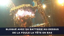 Bloqué avec sa batterie au-dessus de la foule la tête en bas