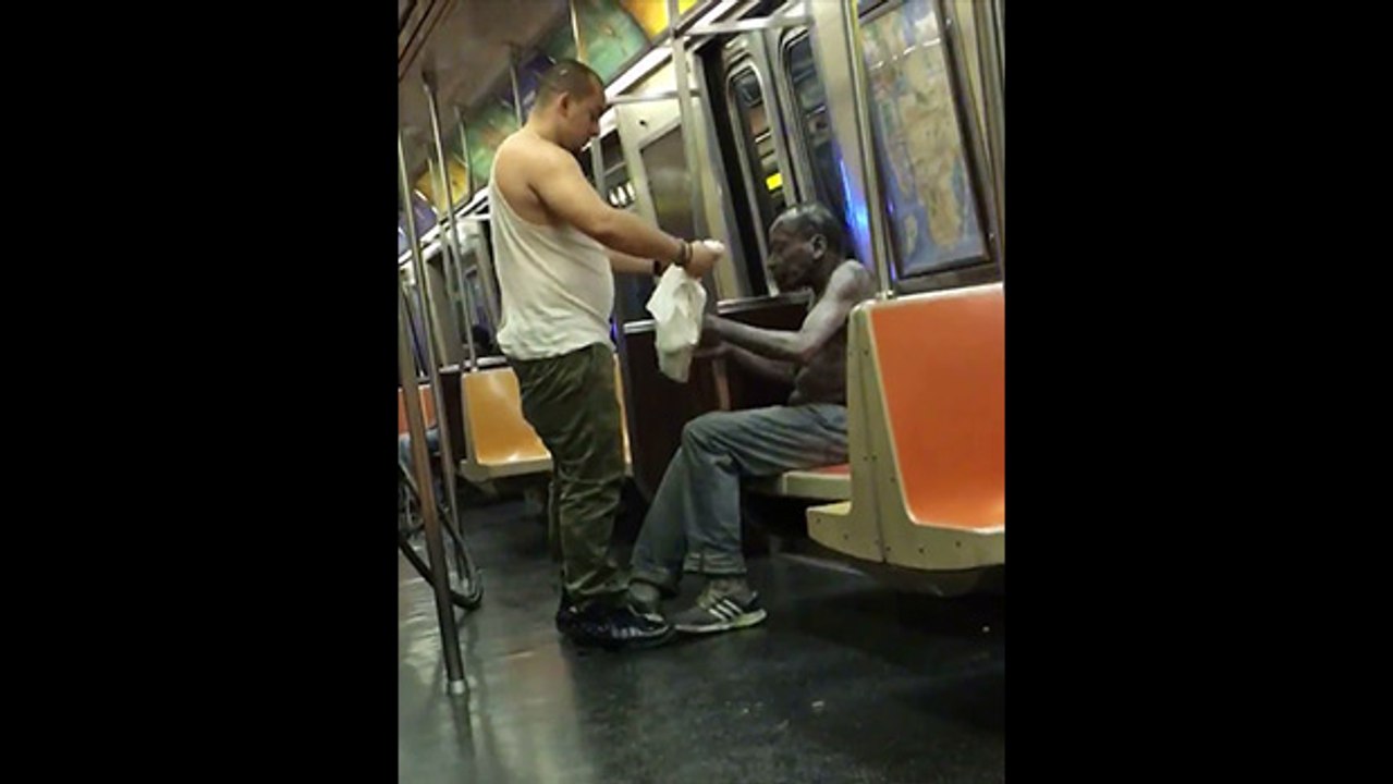 Un homme donne son tee-shirt et son bonnet à un SDF