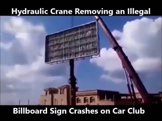 Une grue se retourne en essayant d'enlever un panneau publicitaire illégal