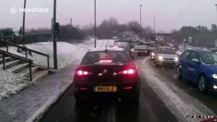 Man slips over on ice while trying to help stuck car
