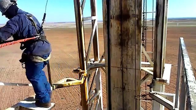 Derrickman pulling blocks latching pipe on an oilfield