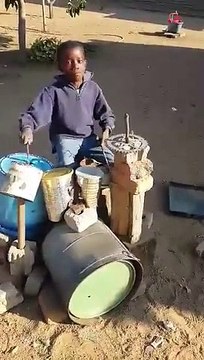 Un jeune batteur africain joue avec les moyens du bord